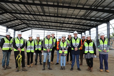 Councillors and staff inside the sports stadium structure